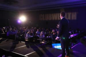 Michael Hellickson of Club Wealth speaks on stage